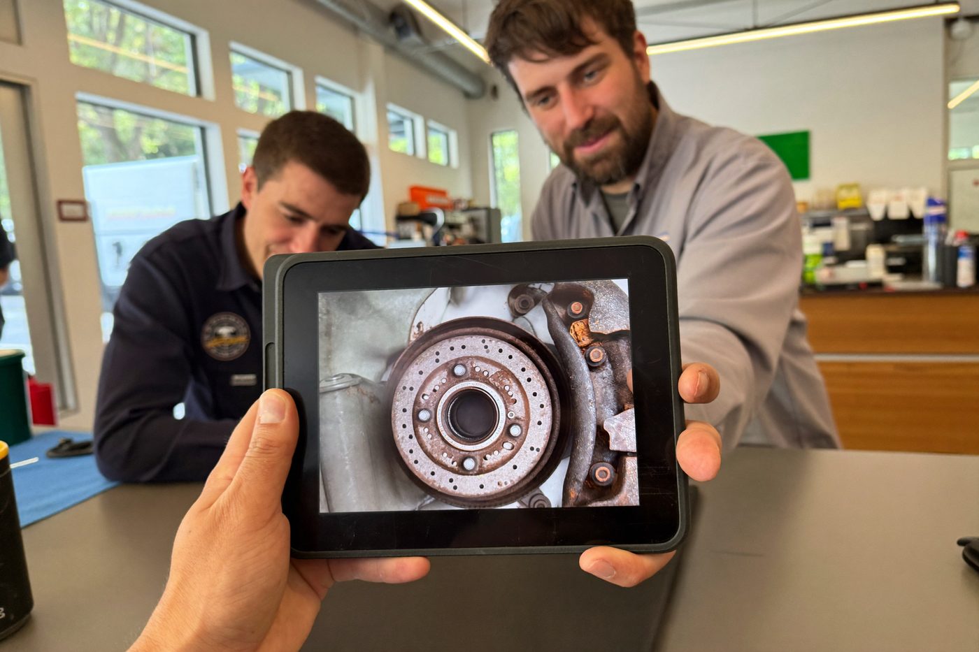 Service advisor showing a brake photo on a tablet to a customer